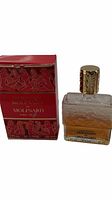 Photo of Molinard de Molinard perfume bottle and original box showing front view with perfume amber liquid visible and embossed glass design.
