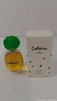 Cabotine de Grès 50ml Eau de Parfum clear glass bottle with amber liquid and green flower-shaped cap, alongside white box featuring brand name and floral decorations.