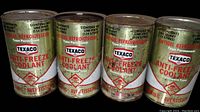 Four vintage Texaco Anti-Freeze Coolant Imperial quart cans showing front labels with text in English and French, some wear and rust visible.