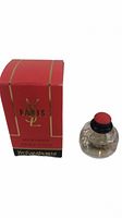 Red Yves Saint Laurent Paris Eau De Toilette box with gold logo and text alongside a small round fragrance bottle with red and black cap.