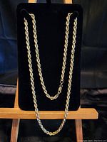 Rope chain displayed against black velvety backdrop on small wooden easel