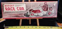Photo of top of box showing vintage artwork and title 'Midget Race Car' with racing driver illustration.
