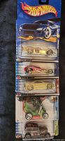 Photo showing five Hot Wheels cars in original sealed packaging arranged vertically.
