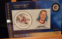 Blue background with 46 cent Gordie Howe stamp and portrait, commemorating the 56th NHL All-Star Game from year 2000.