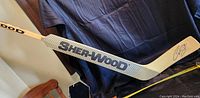 Full view of the Sher-Wood branded hockey goalie stick with Curtis Joseph signature on the blade.