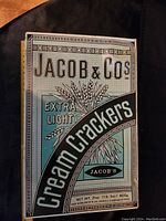 Front side of Jacob & Co Extra Light Cream Crackers tin showing brand and product details.