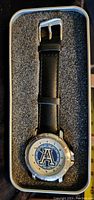 Photo showing the full wristwatch with black leather strap and Toronto Argonauts logo on the dial, presented in foam packaging.