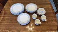 Full set of Royal Porcelain Gardenia dinnerware for 4 displayed on wooden table, showing all items in the set.
