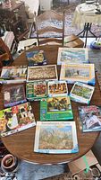 Overview of all puzzle boxes arranged on a table showing a variety of themes and brands including historical scenes, animals, and art.