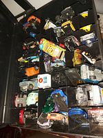 Multiple Hot Wheels toy cars in assorted colors and models inside a carrying case.