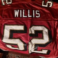 Back view of red football jersey showing 'WILLIS' name and number '52' on the back with black and white stitching.
