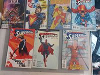 Photo showing eight DC Comics issues including Justice Illustrated, Shazam, Thunderworld Adventures, Superman, and Supergirl with clear cover art and titles visible.