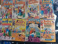 Photo showing nine vintage comic books featuring characters from the Archie universe including Archie, Betty, Veronica, Jughead, and friends.