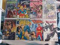 Photo showing eight comic books with various superhero themes and titles.