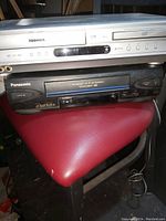 Photo showing two VHS players stacked: a silver Toshiba DVD/VHS combo unit and a black Panasonic VHS player with 4 head Hi-Fi stereo technology.