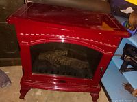 Electric fireplace with red wood or wood-like housing and glass panel front