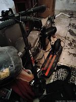 Front view of black Seal Up electric scooter with padded seat, handlebar with controls, front suspension and wide deck with red stripes.