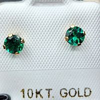 Close-up of green onyx stud earrings mounted in 10k gold, displayed on white card marked 10KT GOLD.
