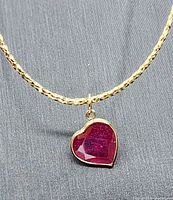 Close-up view of heart-shaped faceted ruby pendant bezel-set in 10k yellow gold
