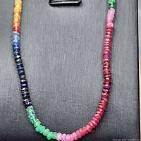 Close-up of faceted multicolored gemstone beads on black background