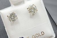 Pair of round brilliant diamonds in four-prong 14k white gold settings captured front-on