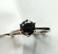 Top-down view of ring showing round black diamond and six-prong setting