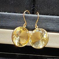 Front view of pair of drop earrings with round yellow citrine stones set in yellow gold bezels with hook wires