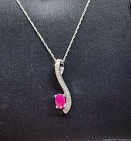 Front view of pendant and chain on black background