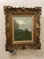 Front view of the original framed oil painting with landscape and figure. The ornate antique gold frame with detailed carvings surrounds the artwork.