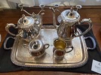 Full set arranged on black cloth: tray, two pots, sugar bowl, creamer and two candle holders