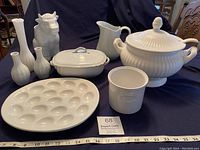 Photo showing all items on dark cloth including tureen, casserole, utensil holder, deviled egg dish, pitcher, and vases