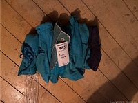 Teal Birks-branded fabric roll folded with MaxSold tag visible