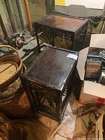 Four tables nested together in a basement setting surrounded by pipes and other items