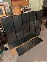 Six framed rectangular slate art panels by Gunter Nolte, dark matte slate surface in black frames shown leaned together on floor.