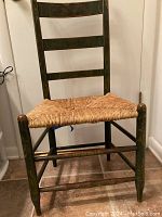 Child sized wooden ladder back chair with hand painted yellow floral details and natural woven rush seat, showing original finish and sittable condition.