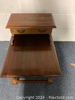 Top and front view of one cherry country colonial end table showing two small drawers with metal handles and lower shelf, in faux antique finish.