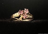 Front view of the yellow gold ring showing three purple amethyst stones and small diamond accents on the shoulders.