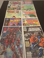 Photo showing 10 comics laid out in two rows, all bagged and boarded, titles clearly visible including Dark Water, Zealots of the Dead Seas, Arak Son of Thunder among others.