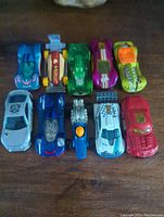 Top-down photo of 10 Hot Wheels toy cars arranged in 2 rows, showing diverse colors and designs.
