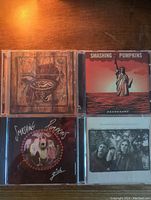 Front covers of four Smashing Pumpkins CDs: Gish, Zeitgeist, Greatest Hits, Machina: The Machines of God