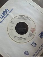 Photo of side B label of 7-inch vinyl showing song "Hearts and Bones" by Paul Simon, with Warner and Warner/Elektra/Atlantic logos on paper sleeve.