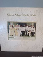 Front cover of the Cheech and Chong's Wedding Album vinyl featuring the wedding party photo with white floral embossed background.