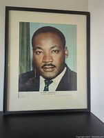 Framed print with portrait of Dr. Martin Luther King Jr. shown in full within black frame and cream mat.