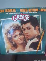 Front cover of Grease double vinyl album showing John Travolta and Olivia Newton-John with Grease title.