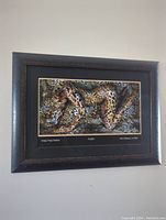 Front view of framed Craig Tracy print featuring a woman body-painted as a leopard on leopard background.