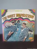 Front cover of The Sweet Inspirations 1967 vinyl album showing band members and colorful wavy border design.