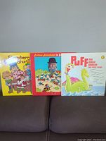 Front view of three children's record albums: Puff the Magic Dragon, Father Abraham in Smurfland, and Strawberry Shortcake Happy Birthday Record. Covers and artwork are visible.