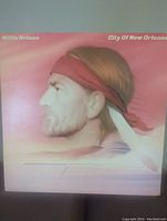 Front cover of the Willie Nelson City of New Orleans vinyl record showing profile portrait of Willie Nelson with a red bandana against a pink background.