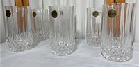 Six clear lead crystal glasses arranged in two rows showing their vertical ribbed and faceted base design.
