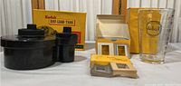 Wide view of Kodak Day-Load Tank, original box, Kodak measuring glass and Kodak packaging materials.